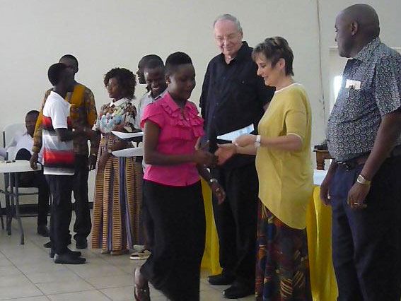 Members of the HZ Mission Team hand out diplomas to Joy in the Harvest Computer School Graduates in Tanzania, Africa.